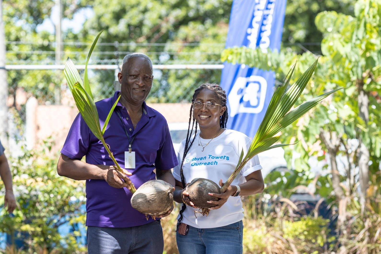 NHT Social Development Officer, Cherton DaCosta (left) and Cavelle McInnis from the Ruthven Towers Outreach Programme joined forces to plant coconut trees on property.